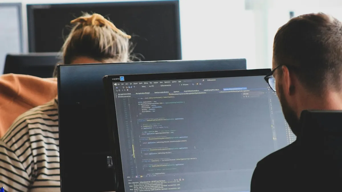 Developers working at computer monitors in a bright office