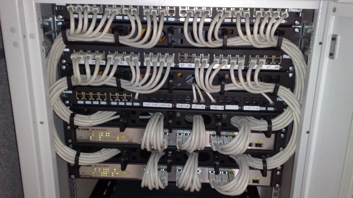 Rack-mounted Ethernet switches and patch panels in a network cabinet
